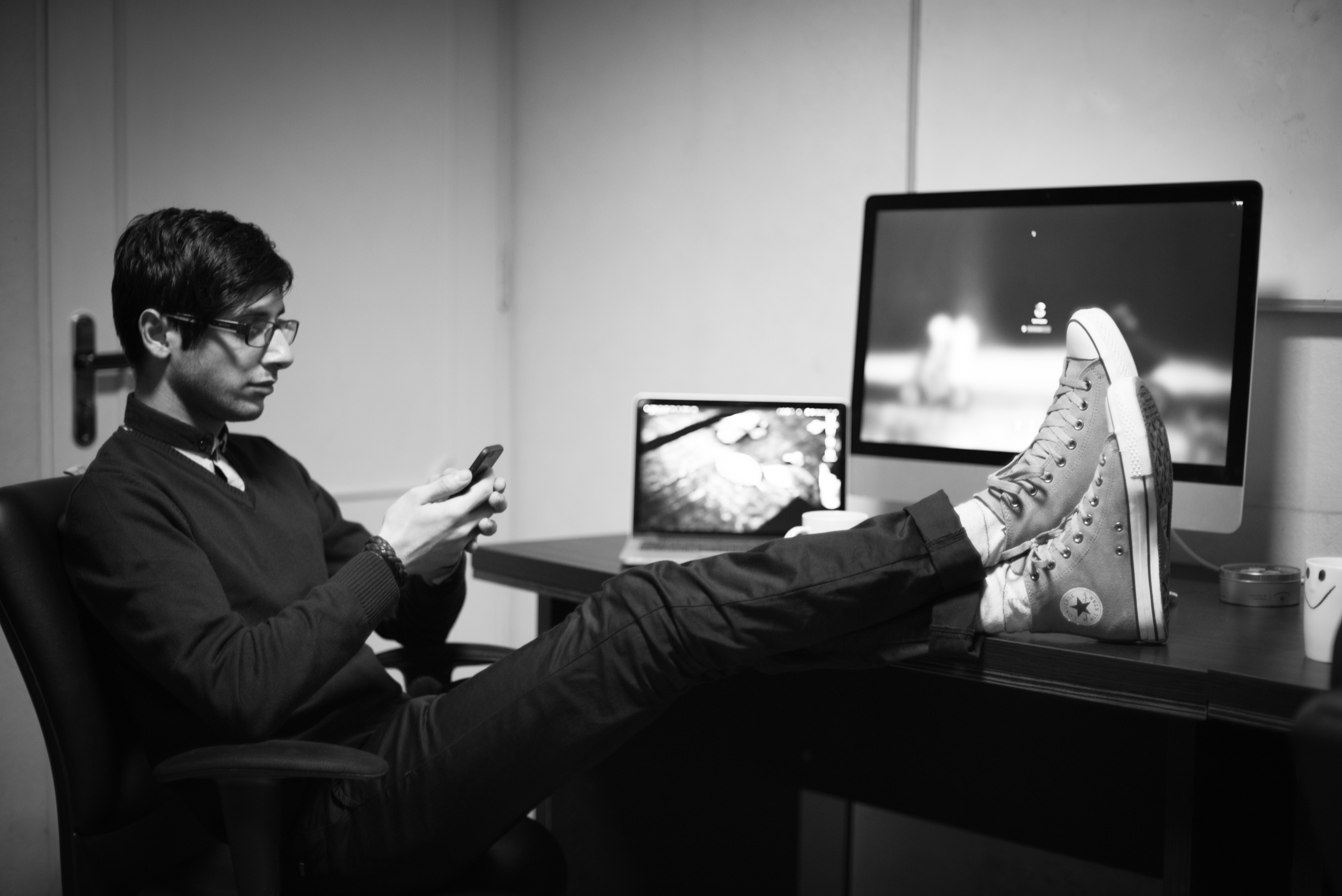 Person's feet on desk, Photo by Kamyar Rad on Unsplash